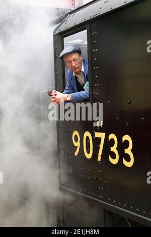 Ein Motorfahrer oder Ingenieur in der Kabine eines Dampfzug Lokomotive Nummer 90733 2-8-0 auf der Keighley & Worth Valley Heritage Linie in Yorkshire Stockfoto