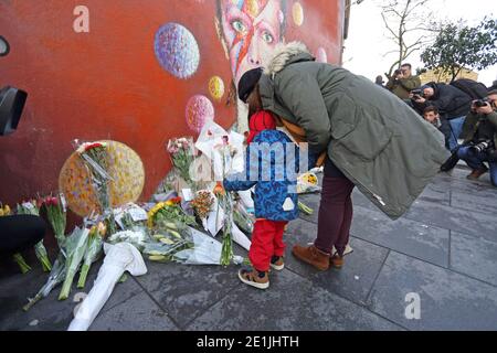 London, Großbritannien. 11th. Januar 2016. Fans versammeln sich am David Bowie Wandgemälde in Brixton, im Süden Londons, zu einer abendlichen Mahnwache, um Blumen zu legen Stockfoto