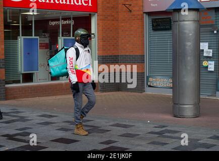 Slough, Berkshire, Großbritannien. Januar 2021. Ein Just Eat Delivery Mann. Slough war heute am zweiten Tag der neuen Covid-19 Nationalsperre viel ruhiger als sonst. Die Zahl der positiven Covid-19-Fälle in Slough ist außer Kontrolle geraten. Für die sieben Tage bis zum 2. Januar 2021 waren die Zahlen pro 100,000 für Slough 1064.6 gegenüber 722.2. Die durchschnittliche Zahl in ganz England ist nur 606.9 für den gleichen Zeitraum. Quelle: Maureen McLean/Alamy Live News Stockfoto