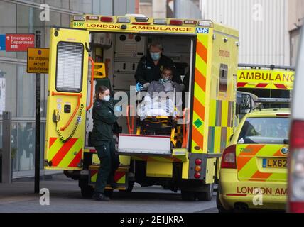 London, Großbritannien. Januar 2020. Ein Patient kommt im Krankenhaus an. Krankenwagenlinien außerhalb des Royal London Hospital, da der NHS unter starkem Druck steht, da die Fälle von Covid-19 zunehmen. Das Vereinigte Königreich ist nach dem großen Anstieg der Covid-Fälle in eine nationale Lockdown-Liste übergegangen. Im Vereinigten Königreich gab es über 2.8 Millionen bestätigte Fälle mit über 77,000 Todesfällen. Kredit: Mark Thomas/Alamy Live Nachrichten Stockfoto