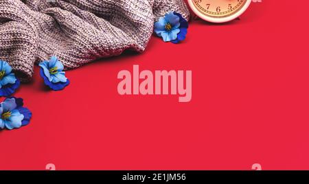 Frühling frischer und gemütlicher Hintergrund mit Blumen, Wecker und Strickpullover, Konzept Banner Foto Stockfoto