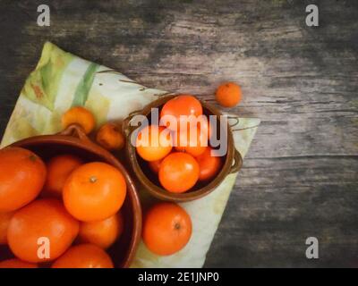 Orangen, Mandarinen Orangen, Mandarinen, alle Zitrusfrüchte in Schale und auf einem ländlichen Küchentisch Stockfoto