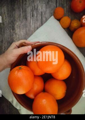 Orangen, Mandarinen Orangen, Mandarinen, alle Zitrusfrüchte in Schale und auf einem ländlichen Küchentisch Stockfoto