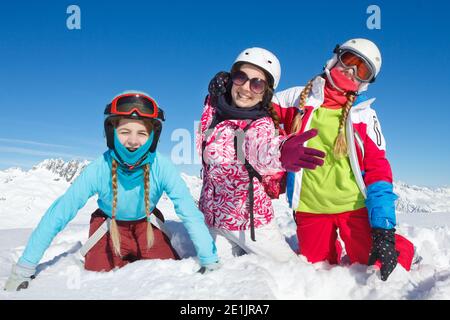 Glückliche Kinder im Winterurlaub in Frankreich spielen frisch Schnee und Pose für die Kamera auf Skipisten Stockfoto