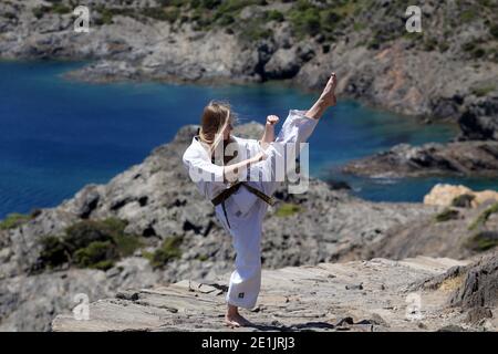 Ein Mädchen in Karate, Training in den Bergen, mit Blick auf das Meer Stockfoto