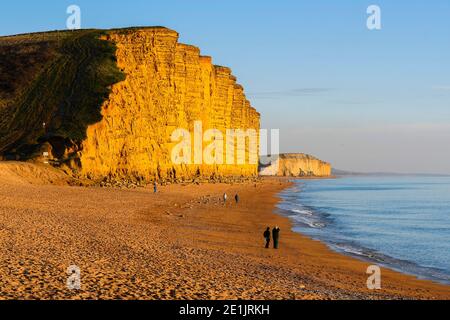 West Bay, Dorset, Großbritannien. Januar 2021. Wetter in Großbritannien. An einem kalten, sonnigen Tag leuchten die Klippen golden orange in der späten Nachmittagssonne am fast menschenleeren Strand von West Bay in Dorset. Bild: Graham Hunt/Alamy Live News Stockfoto