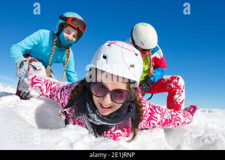 Glückliche Familie auf Winte Urlaub mit blauem Himmel und bunt Kleidung, die im frischen Schnee auf den Skipisten spielt Der Haute savoie Stockfoto