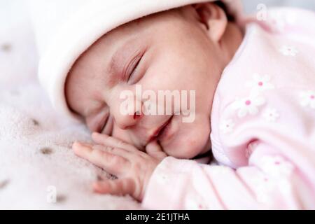 Kindheit, Krankheit, Koliken, Blähungen, Mutterschaft, Gesundheit Konzepte - Close up unruhig, besorgt traurig neugeborenen Mädchen im Hut schläft weinen schreien haben Stockfoto