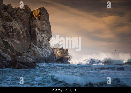 Stürmischer Pazifik und Morro Rock bei Sonnenuntergang. Morro Bay State Park, kalifornische Küste Stockfoto