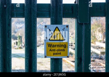 Warnschild - Anti-Climb-Farbe am Metallzaun angebracht Stockfoto