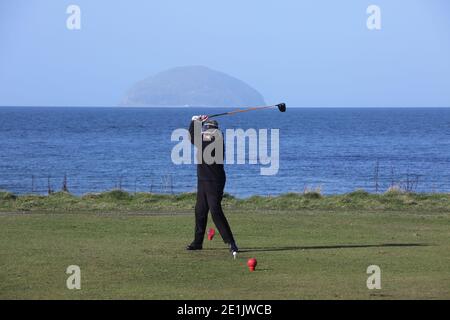 Städtischer Golfplatz Girvan, Ayrshire, Schottland, Großbritannien. Golferin auf dem ersten T-Shirt mit Ailsa Craig im Hintergrund Stockfoto