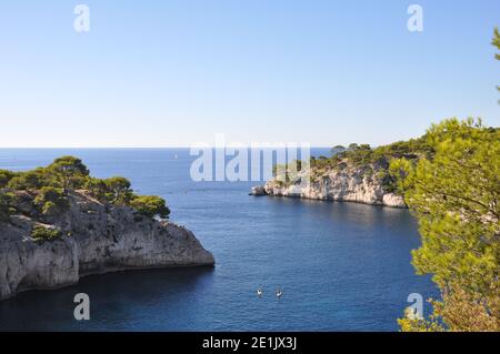 Steh auf Paddler zwischen Klippen auf dem Meer, Calanques, Bouches-du-Rhône, Cassis, Südfrankreich Stockfoto
