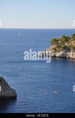 Steh auf Paddler zwischen Klippen, Calanques, Bouches-du-Rhône, Cassis, Südfrankreich Stockfoto