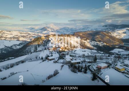 Luftpanorama der Stadt Ruino in Oltrepo Pavese bedeckt Im Schnee während Sonnenuntergang in Lombardei Italien Stockfoto