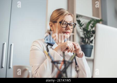 Der Oberarzt verwendet im Büro einen Laptop Remote mit Patienten online Stockfoto