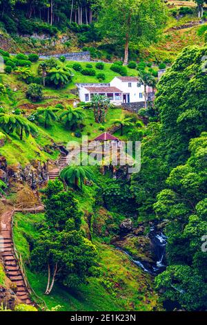 Wasserfall im Parque Natural Da Ribeira Dos Caldeiroes, Sao Miguel, Azoren, Portugal. Schöner Wasserfall umgeben von Hortensien in Ribeira dos Ca Stockfoto