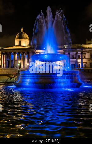 London, Großbritannien. Januar 2021. The Fountains in Trafalgar Sqaure - Londons Skyline ist blau beleuchtet in einer erneuerten Geste des Dankes an den NHS und die Front-Arbeiter, ab Donnerstag, 7. Januar. Wahrzeichen, historische Gebäude und große Sport- und Unterhaltungsorte sind blau beleuchtet - einschließlich London Eye, Trafalgar Square, County Hall und Wembley Arch. Der Bürgermeister von London Sadiq Khan unterstützt die Kampagne. Es ist die erste Woche der nationalen Lockdown 3. Dies ersetzt Tier-4-Beschränkungen und die Regierung Anweisung ist für alle zu Hause zu bleiben, um den Druck auf die NHS zu sparen. Kredit: Guy Bell/Ala Stockfoto