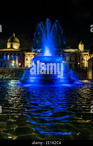 London, Großbritannien. Januar 2021. The Fountains in Trafalgar Sqaure - Londons Skyline ist blau beleuchtet in einer erneuerten Geste des Dankes an den NHS und die Front-Arbeiter, ab Donnerstag, 7. Januar. Wahrzeichen, historische Gebäude und große Sport- und Unterhaltungsorte sind blau beleuchtet - einschließlich London Eye, Trafalgar Square, County Hall und Wembley Arch. Der Bürgermeister von London Sadiq Khan unterstützt die Kampagne. Es ist die erste Woche der nationalen Lockdown 3. Dies ersetzt Tier-4-Beschränkungen und die Regierung Anweisung ist für alle zu Hause zu bleiben, um den Druck auf die NHS zu sparen. Kredit: Guy Bell/Ala Stockfoto