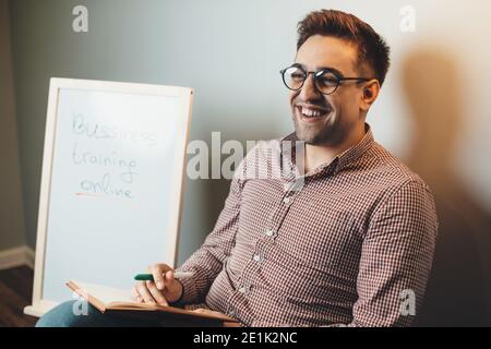 Kaukasischer Mann mit Brille spricht und lächelt beim Haben Online-Business-Kurse Stockfoto