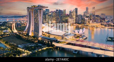 Blick von oben, atemberaubende Luftaufnahme der Skyline von Singapur bei einem wunderschönen Sonnenuntergang mit dem Finanzviertel in der Ferne. Singapur. Stockfoto