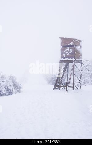 Jagdturm im verschneiten und nebligen Wald. Niemand Stockfoto