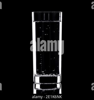 Glas Wasser mit Blasen, die auf schwarzem Hintergrund aufsteigen Stockfoto