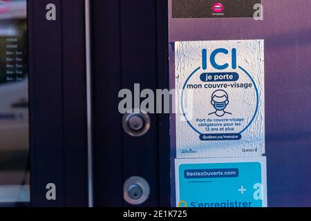 Montreal, CA - 6. Januar 2021: Beschilderung, die besagt, dass nicht-medizinische Masken oder Gesichtsbedeckungen erforderlich sind, um den Laden zu betreten Stockfoto