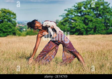 Frau, die Yoga mit ihrem Hund .Doga Yoga mit Ihrem Hund. Stockfoto