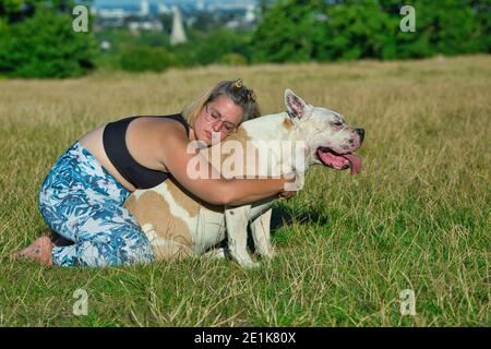 Frau, die Yoga mit ihrem Hund .Doga Yoga mit Ihrem Hund. Stockfoto