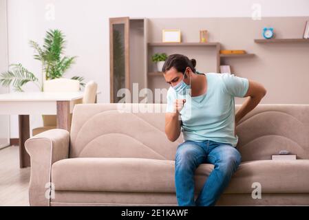 Junger Mann Student Husten zu Hause während Pandemie Stockfoto