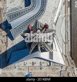 Arbeiter Installateure in der Höhe arbeiten an der Spitze des Wolkenkratzers. Stockfoto