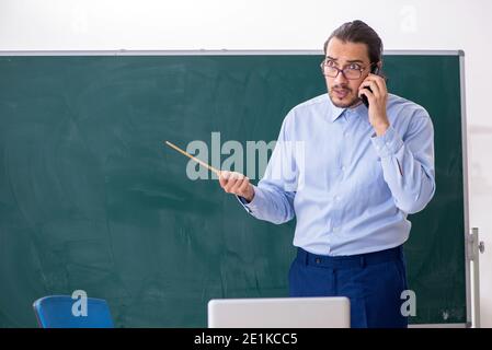 Junge Lehrerin im Klassenzimmer vor dem Green Board Stockfoto