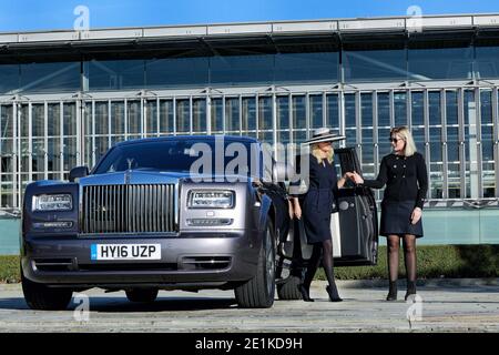 Weibliche Chauffeur, die die Autotür für vip-Kunden öffnet Stockfoto