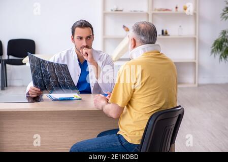 Alter Hals verletzten Mann besucht jungen Arzt Radiologen Stockfoto
