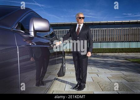 Chauffeur öffnet Autotür für vip-Kunden Stockfoto