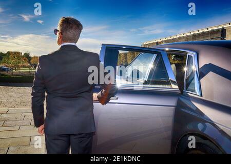 Chauffeur öffnet Autotür für vip-Kunden Stockfoto