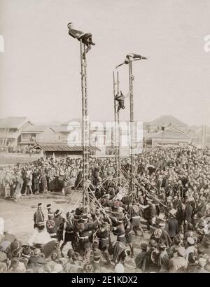 Vintage-Fotografie des 19. Jahrhunderts: Akrobatische Darstellung durch japanische Feuerwehrleute mit Leitern. Diese Ausstellungen scheinen Teil der Feierlichkeiten zum neuen Jahr gewesen zu sein. Stockfoto