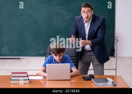 Männlicher Lehrer und Schuljunge im Klassenzimmer Stockfoto
