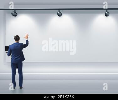 Geschäftsmann drücken virtuelle Taste auf der Wand leuchtet mit Strahlern Stockfoto