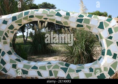 Eine Umfassungsmauer zu einem Park in Guardamar an der Costa Blanca, Spanien. Erstellt aus zerbrochenen Fliesen zu einem Mosaik in weißem Beton gesetzt zu bilden. Stockfoto