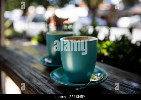 Geringe Schärfentiefe Bild von zwei grünen Kaffeetassen Gefüllt mit Cappuccino Stockfoto
