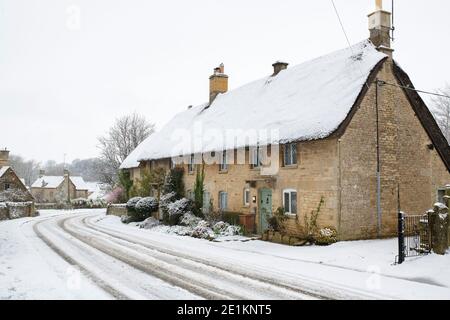 Cotswold Stein Reethäuser im Schnee zu Weihnachten. Taynton, Cotswolds, Oxfordshire, England Stockfoto