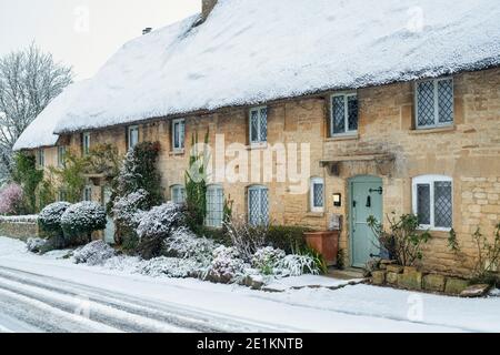 Cotswold Stein Reethäuser im Schnee zu Weihnachten. Taynton, Cotswolds, Oxfordshire, England Stockfoto