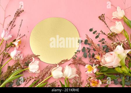 Hoher Winkel von verschiedenen blühenden Blumen und Pflanzen angeordnet auf Rosa Hintergrund mit golden glänzend runden Papier Stockfoto