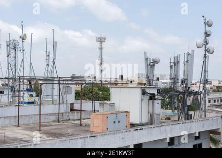 Telekommunikationsturm der 4G- und 5G-Mobilfunkbasisstation auf einem Dach eines Hauses. Antennensender Für Drahtlose Kommunikation. Stockfoto