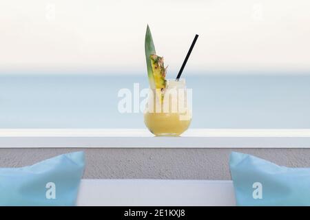 Köstlich aussehender Pina Colada Cocktail mit einem Strohhalm auf einem unscharf-hellen Hintergrund. Selektiver Fokus. Freizeit- und Lifestyle-Konzept. Stockfoto