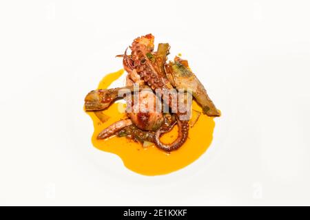 Frisch zubereiteter Oktopus mit Artischocke auf hellem Hintergrund. Draufsicht. Essen und Kochen Konzept. Stockfoto