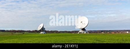 Raisting, Deutschland - 13. Nov 2020: Zwei Satellitenschüsseln zeigen in Richtung Himmel. In schöner bayerischer Landschaft. Teil des Raisting Radome. Stockfoto