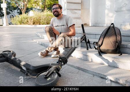 Junger Mann Unfall Mit Einem Elektroroller Auf Der Straße. Ein Mann fiel von einem Roller auf einer Stadtstraße. Stockfoto