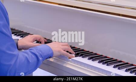 Mann Hände spielen auf weißem Flügel auf Konzert - Nahaufnahme Stockfoto